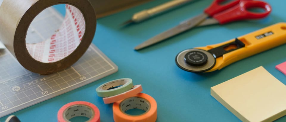 Various crafting tools spread out on a bright blue surface.