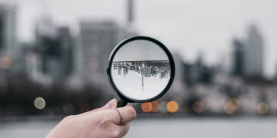 A magnifying glass held up to a city skyline.